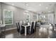 Dining room features a modern table with seating for six, complemented by bright natural light at 1873 White Feather Loop, Oakland, FL 34787