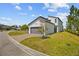 Modern two-story home exterior showcasing a gray two-car garage, fresh green grass, and landscaping at 1873 White Feather Loop, Oakland, FL 34787