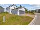 Exterior view of modern home with gray two-car garage, and lush green landscaping at 1873 White Feather Loop, Oakland, FL 34787