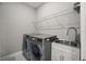 Laundry room featuring modern washer and dryer, along with a utility sink and storage at 1873 White Feather Loop, Oakland, FL 34787