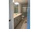 Bathroom boasts a double vanity, grey cabinets, and a glass enclosed shower at 2081 Viewfinder St, Kissimmee, FL 34758