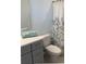 Bathroom features a grey vanity, decorative mirror, and a shower with a floral patterned shower curtain at 2081 Viewfinder St, Kissimmee, FL 34758