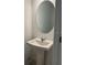 A well-lit half bathroom showcases a pedestal sink, modern faucet and oval mirror at 2081 Viewfinder St, Kissimmee, FL 34758