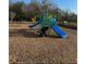A community playground with blue slides is surrounded by mulch in a natural setting at 2081 Viewfinder St, Kissimmee, FL 34758