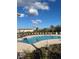 An outdoor community pool with lounge chairs and umbrellas surrounded by landscaping at 2081 Viewfinder St, Kissimmee, FL 34758