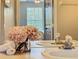 Bathroom vanity with dual sinks, rolled towels and decorative floral accent at 2300 Silver Palm Dr # 205, Kissimmee, FL 34747