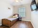 This is a cozy bedroom with a twin bed, wood floors, and a TV on the wall at 2300 Silver Palm Dr # 205, Kissimmee, FL 34747