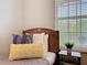 A comfortable bedroom with a wooden bed, soft pillows, and a window at 2300 Silver Palm Dr # 205, Kissimmee, FL 34747