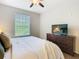 Bright bedroom with a large window, ceiling fan, and stylish dresser with a modern TV at 2300 Silver Palm Dr # 205, Kissimmee, FL 34747