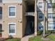 Beige two-story condo building featuring stairs, windows, and well-maintained landscaping at 2300 Silver Palm Dr # 205, Kissimmee, FL 34747