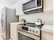 Modern kitchen featuring stainless steel appliances, white cabinets, and a stylish range at 2300 Silver Palm Dr # 205, Kissimmee, FL 34747
