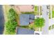 Aerial view of a home with a gray roof, surrounded by lush greenery and a nearby lake at 2308 Holly Pine Cir, Orlando, FL 32820