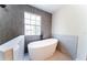 Modern bathroom with a soaking tub, walk-in shower, and patterned accent wall at 2308 Holly Pine Cir, Orlando, FL 32820
