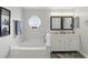 Bathroom features double vanity with marble countertop and soaking tub under an octagon window at 2423 Auld Scot Blvd, Ocoee, FL 34761