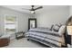 Inviting bedroom featuring a large mirror, a striped bedspread, and a view of the outdoors at 2423 Auld Scot Blvd, Ocoee, FL 34761