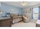 Light and airy Bedroom featuring custom accent wall, crib, and comfortable recliner at 2423 Auld Scot Blvd, Ocoee, FL 34761