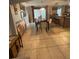 Dining room featuring large glass table, kitchen breakfast bar, and modern chandelier at 2737 Merrieweather Ln, Kissimmee, FL 34743