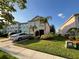 Exterior view of a well-manicured lawn and landscaping in front of a pink two-story townhouse at 2737 Merrieweather Ln, Kissimmee, FL 34743
