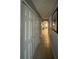 Bright hallway featuring tile flooring, neutral paint, and white doors for storage and access to other areas at 2737 Merrieweather Ln, Kissimmee, FL 34743