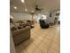 Living room with tile flooring, a ceiling fan, neutral paint and multiple seating options at 2737 Merrieweather Ln, Kissimmee, FL 34743