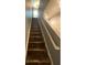 Carpeted staircase featuring neutral paint on the walls and white trim leading to the upper level of the home at 2737 Merrieweather Ln, Kissimmee, FL 34743