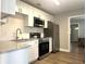 Modern kitchen featuring stainless steel appliances, white cabinetry, and stone countertops at 2975 Avenue G Nw, Winter Haven, FL 33880