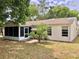 Rear view of home with screened porch, landscaped yard, and vinyl siding at 307 Santa Clara Cir, Lady Lake, FL 32159