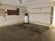 Spacious garage with water heater, peg board, shelves, and door to the outside at 307 Santa Clara Cir, Lady Lake, FL 32159