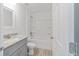 Bathroom featuring a shower-tub, granite counters and gray cabinets at 315 Fisher Rd, Ocklawaha, FL 32179