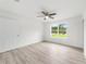Empty bedroom featuring laminate flooring, a door to the hallway, and a window at 315 Fisher Rd, Ocklawaha, FL 32179