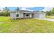 New construction home featuring a manicured front lawn and a spacious two-car garage at 315 Fisher Rd, Ocklawaha, FL 32179