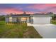 Charming single-story home with a two-car garage and a well-manicured lawn at sunset at 315 Fisher Rd, Ocklawaha, FL 32179