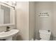 Bathroom with a white pedestal sink, toilet, and decorative shelving for extra storage at 3251 Oak Lake Pl # 135, Winter Park, FL 32792