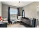 Cozy bedroom with a crib, neutral colors, and ample natural light at 3251 Oak Lake Pl # 135, Winter Park, FL 32792