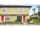 Inviting townhome showcasing a vibrant red door and lush landscaping at 3251 Oak Lake Pl # 135, Winter Park, FL 32792