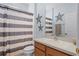 Bathroom featuring a single sink vanity, toilet, and tub/shower combo with striped curtain at 3416 Gerber Daisy Ln, Oviedo, FL 32766