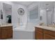 Bright main bathroom with a large soaking tub, double vanities, and a window at 3416 Gerber Daisy Ln, Oviedo, FL 32766