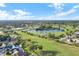 Wide aerial view of golf course community, clubhouse, lake, and single-Gathering homes at 3617 Cherry Hill Dr, Orlando, FL 32822