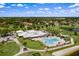 Aerial view of a community clubhouse, pool, and golf course amidst lush greenery at 3617 Cherry Hill Dr, Orlando, FL 32822