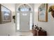 Bright foyer with tile flooring, decorative wall mirrors, and an arched window above the front door at 3617 Cherry Hill Dr, Orlando, FL 32822