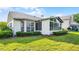 Home exterior featuring well-maintained lawn, manicured bushes, and glass-walled Florida room at 3617 Cherry Hill Dr, Orlando, FL 32822