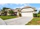 Elegant home with a manicured lawn, palm trees, and an attached two-car garage at 3617 Cherry Hill Dr, Orlando, FL 32822