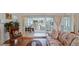 Cozy armchair sits adjacent to glass sliders to sunroom, enhancing views of backyard at 3617 Cherry Hill Dr, Orlando, FL 32822
