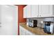 Wet bar area includes a granite countertop, white cabinets, tile backsplash, and modern appliances at 3617 Cherry Hill Dr, Orlando, FL 32822