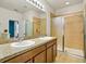 Bathroom featuring double sinks, granite countertops, and a glass door shower at 3808 Enchantment Ln, St Cloud, FL 34772