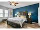 Beautiful bedroom with a ceiling fan, wood floors, and a dark blue accent wall at 3808 Enchantment Ln, St Cloud, FL 34772