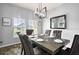 Elegant dining room with a modern chandelier, wood floors, and plentiful natural light from the large windows at 3808 Enchantment Ln, St Cloud, FL 34772