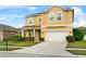 Inviting two-story home featuring a well-manicured lawn, lush landscaping, and an attached two-car garage at 3808 Enchantment Ln, St Cloud, FL 34772