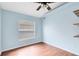 Simple bedroom with laminate wood flooring, a ceiling fan, and a large window at 428 Winding Oak Ln, Longwood, FL 32750