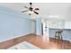Bright living room with a ceiling fan, wood floors, and an adjacent open kitchen area at 428 Winding Oak Ln, Longwood, FL 32750